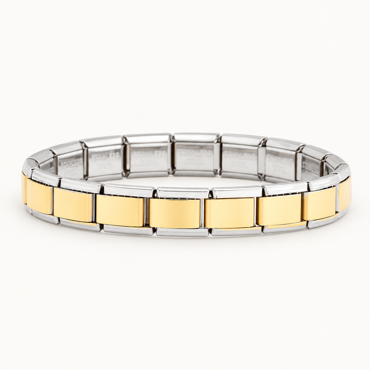 Gold-centre Italian charm bracelet with silver-tone edges on a warm white background